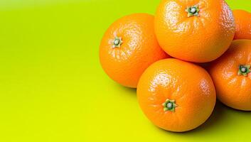 Oranges on colorful backdrop. Five bright oranges are neatly stacked against a lively green background, showcasing their rich color and texture. photo