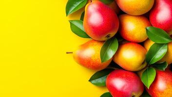 Vibrant apples and pears backdrop. Fresh apples and pears arranged with green leaves against a vibrant yellow background create a lively display. photo