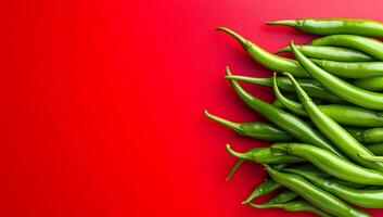 Green chili peppers on red background. Fresh green chili peppers are arranged on a bright red surface, showcasing their vibrant color and freshness. photo