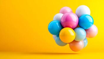 Balloons pop against yellow. A colorful array of balloons floats on a bright yellow background, adding a cheerful vibe. photo
