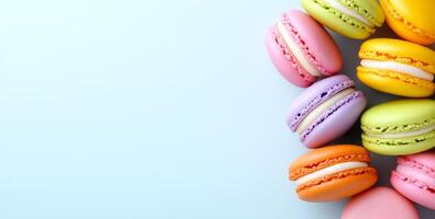 Vibrant macarons on light backdrop. Colorful macarons in different flavors are beautifully arranged on a pale blue surface. photo