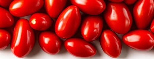 Bright red cherry tomatoes. A close view of various cherry tomatoes showcasing their glossy, vibrant red skin, displayed on a light surface. photo