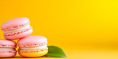 Brightly stacked macarons. Three pastel macarons are arranged with a green leaf, set against a vivid yellow backdrop, creating a cheerful display. photo
