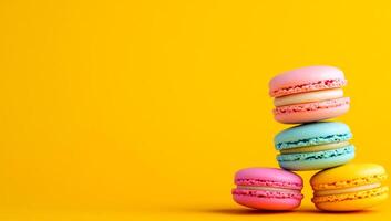 Macarons on yellow backdrop. Delicate macarons in pastel colors are creatively stacked against a bright yellow backdrop, showcasing their elegance. photo