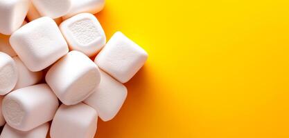 Marshmallows on a bright surface. Fluffy white marshmallows dot a bright yellow background, creating a playful, cheerful vibe. photo