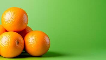 Oranges on green backdrop. Bright, ripe oranges are arranged in a pile against a vibrant green background, showcasing their texture and color. photo