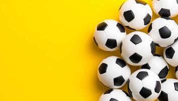 Soccer balls on yellow. Multiple soccer balls are scattered across a bright yellow surface, creating a lively and playful atmosphere. photo