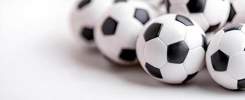 Soccer balls grouped on a flat surface. Several black-and-white soccer balls are arranged closely on a smooth surface, creating an inviting scene. photo