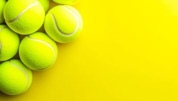 Yellow tennis balls on vibrant court. Several bright yellow tennis balls are arranged on a vivid yellow background, showcasing their texture and color. photo