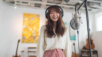 Talented young woman singing passionately into a microphone during a studio recording session. Her joyful expression and focus convey her love for music and dedication to her craft. photo