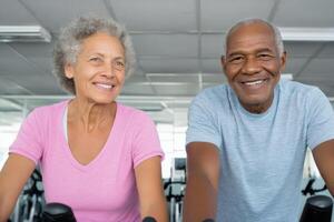 Active Seniors Gym Workout and Healthy Lifestyle. Smiling Elderly Couple Exercising on Stationary Bikes. Fitness, Wellness, and We photo