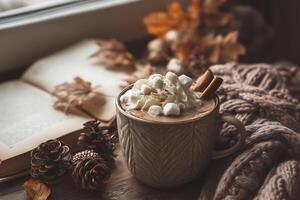 Hot chocolate with marshmallows and cinnamon on a window sill photo