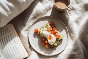 Avocado toast with tomato and egg on a plate with a book and coffee photo