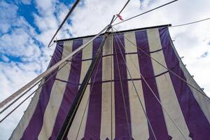 A close-up shot capturing the intricate details of a majestic Viking longship sailing gracefully under clear blue skies, a symbol of ancient maritime adventure and exploration. photo