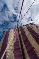 Close-up view of a magnificent Viking ship sailing gracefully on the open sea, with a clear blue sky in the background, evoking a sense of adventure and exploration in ancient times. photo