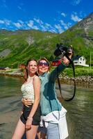 In a trendy urban environment, a stylish woman passionately captures a selfie using a professional camera, epitomizing modernity and creative enthusiasm in photography. photo