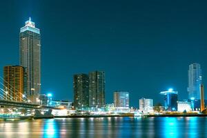 A stunning night panorama of Rotterdam featuring modern high-rise structures illuminated against a starry sky, creating a mesmerizing urban landscape. photo