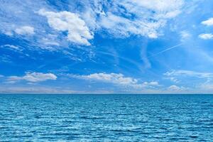 Experience the serene beauty of the ocean, where azure waters meet a vast sky filled with fluffy clouds. A perfect scene for relaxation and contemplation, inviting inspiration. photo