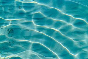 Experience the tranquility of underwater nature with sunlight dancing through clear water, illuminating the sandy seabed. Perfect for themes of travel, relaxation, and serenity. photo