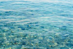 A stunning view of the seabed through crystal-clear, azure water. The underwater pebbles create a serene scene, evoking tranquility and natural beauty, ideal for travel or relaxation. photo