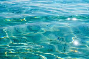 Sparkling Turquoise Water Surface with Sun Reflections and Ripples Abstract Background photo