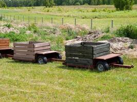 Two wooden crates are sitting in a field photo