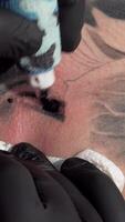 Intense macro shot of a tattoo artist skillfully inking a client's skin video