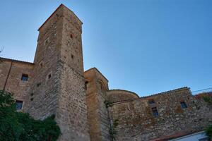 Defensive architecture of the Fortress of Luis de Chaves the Elder in Extremadura, highlighting its medieval watchtower against a serene sky photo
