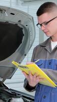 Dedicated mechanic meticulously notes repairs needed on a vehicle video