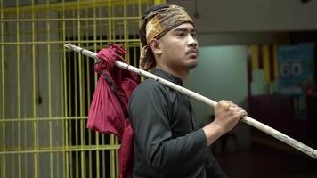 Man in Traditional Attire with Stick in Urban Setting video