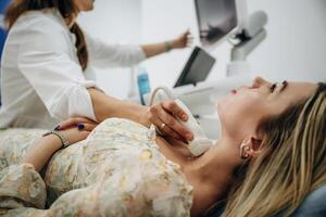 Side view. Woman is lying down and, undergoing ultrasonic test of the thyroid gland photo