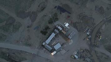 Top-down view of industrial terrain with scattered construction materials, machinery, and muddy access paths, illustrating development and land use transformation. video