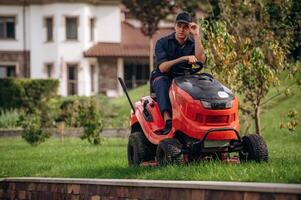 Sitting on, the,, lawn mover. Professional gardener is on the lawn photo