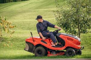 Sitting, on ,,the lawn mover. Professional gardener is on the lawn photo