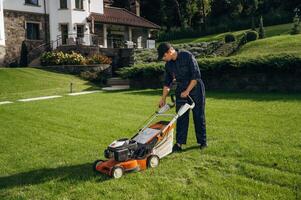 Side view, with, lawn mover. Professional gardener is on the lawn photo