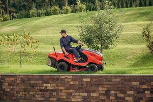 Sitting on the, lawn ,mover. Professional gardener is on the lawn photo
