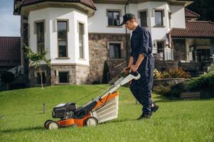 Side ,view, with,, lawn mover. Professional gardener is on the lawn photo