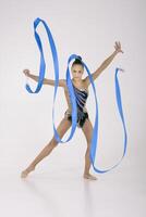 a girl from rhythmic gymnastics in a standing bodysuit, shows an exercise with a ribbon photo