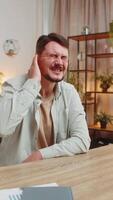 Sick young Caucasian man freelancer sitting at home office table feeling ear pain, unhappy irritated businessman or student. Furuncle, earache, shingles, eczema, ear disease, otitis concept. Vertical. video