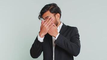 Don't want to look at this, awful. Afraid shocked Indian businessman closing eyes with hand showing stop gesture, confused shy scared reject to watch. Male Arabian man guy isolated on gray background video