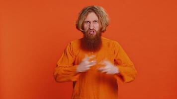 Upset frustrated annoyed Caucasian man raising hands in indignant expression, quarreling asking reason of conflict problem, why such stubborn. Irritated young redhead guy isolated on orange background video