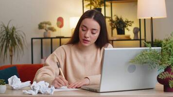 Angry furious Caucasian young woman throwing crumpled paper nervous breakdown at work stress management mental distress problems losing temper reaction on failure. Girl sitting at home office at table video
