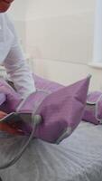Cosmetologist making pressotherapy procedure wearing suit on patient legs indoors. Hardware cosmetology technique used in fight against cellulite. Affects lymphatic system with compressed air supplied video