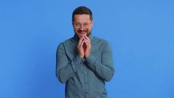 Sneaky cunning Caucasian middle-aged man in glasses with tricky face gesticulating and scheming evil plan, thinking over devious villain idea, cheats, jokes, pranks. Guy isolated on blue background video