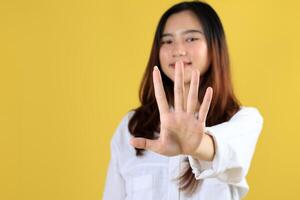 Smiling Blond Young Woman Extend Hand To Show Stop Sign, Rejecting Something with Unbothered Happy Face Expression photo