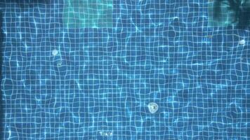 Aerial top-down view of calm blue swimming pool water with sunlight reflections. Ideal for summer, spa, travel, or background themes. Peaceful and minimalist scene. video