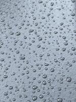 large transparent shiny raindrops fell on a smooth surface, background photo