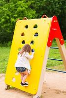 Little girl playing at the playground in a park photo