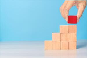 Businessman hand placing or pulling Red wooden block on the building. Business planning, Risk Management, Solution, strategy, Unique Concepts photo