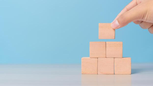 Hand placing empty blocks in a row. Concept of planning, process, or sequence setup. photo